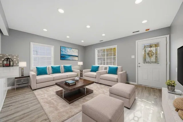 a living room with furniture and a wooden floor