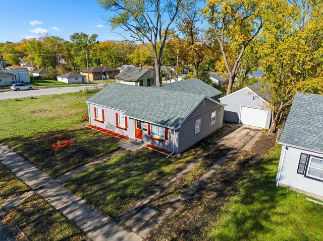 a view of a house with a big yard plants and large trees