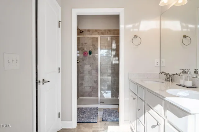 a bathroom with a granite countertop sink mirror and shower