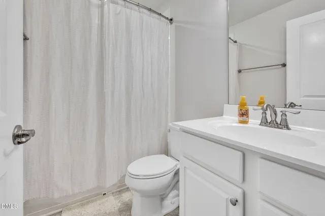 a bathroom with a sink a toilet and shower curtain
