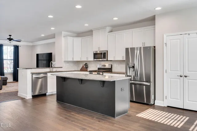 a kitchen with stainless steel appliances a refrigerator stove microwave and sink