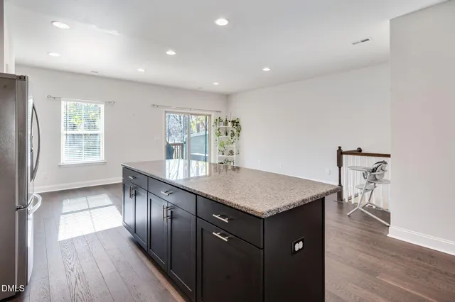a kitchen with a wooden floor and front door