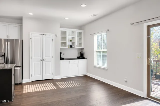 a view of a kitchen with refrigerator and window