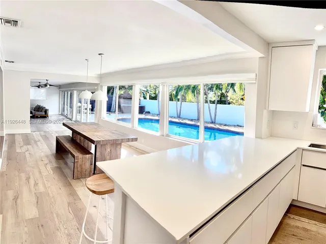 a kitchen with kitchen island a large counter top space and stainless steel appliances