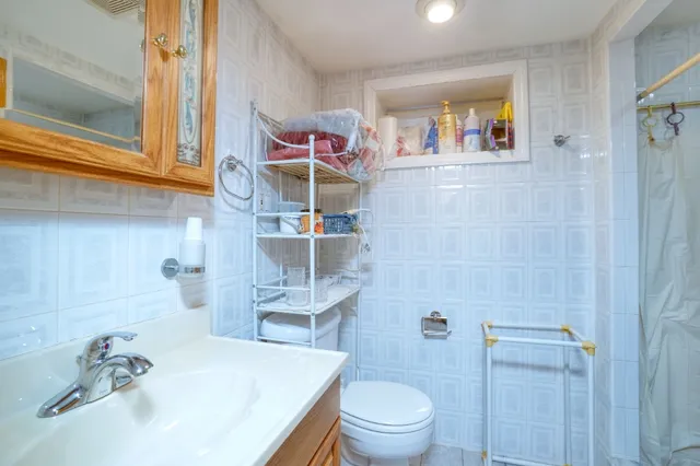 a bathroom with a sink a toilet and shower curtain