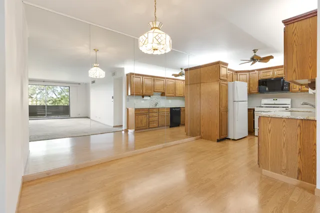 a view of a kitchen with a sink and dishwasher a refrigerator with wooden floor