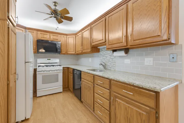a kitchen with stainless steel appliances granite countertop a sink a stove and cabinets