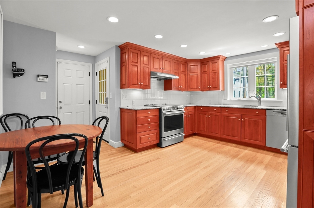 109 Suffolk Road Wellesley, MA 02481 - Photo 3 of 24 a kitchen with stainless steel appliances granite countertop a stove a sink dishwasher and a dining table with wooden cabinet