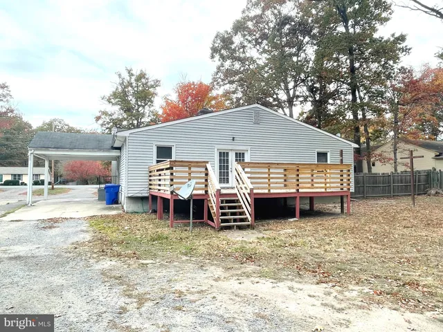 a view of a house with a barbeque and large trees