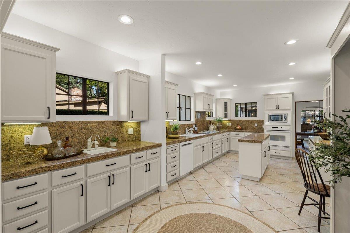 731 5th Street Gilroy, CA 95020 - Photo 11 of 31 a large white kitchen with cabinets and chairs