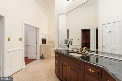 a bathroom with a granite countertop sink and a large mirror