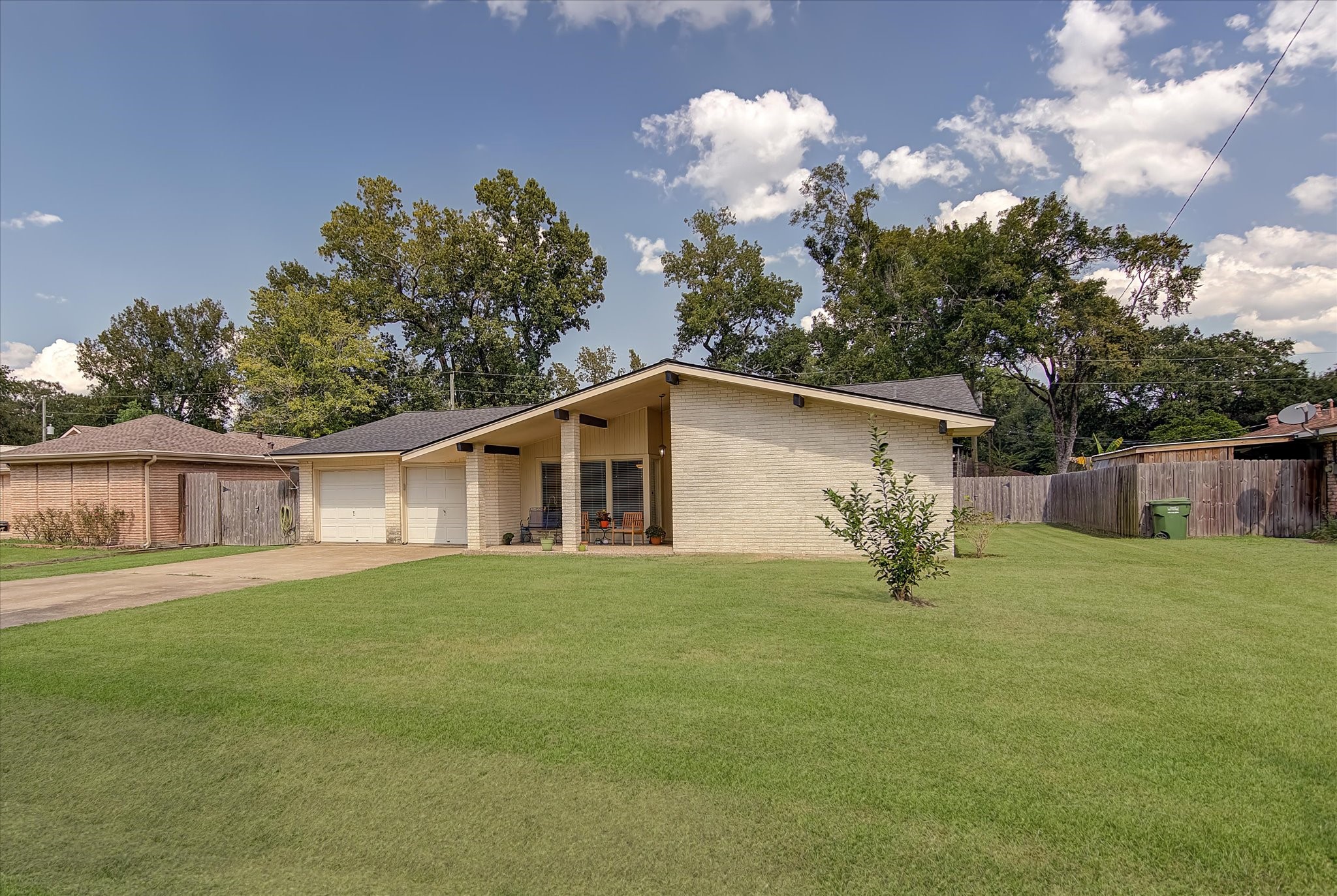 a front view of house with yard and trees in the background