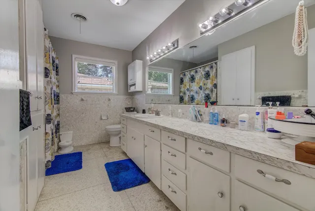 a spacious bathroom with double vanity a mirror and a shower