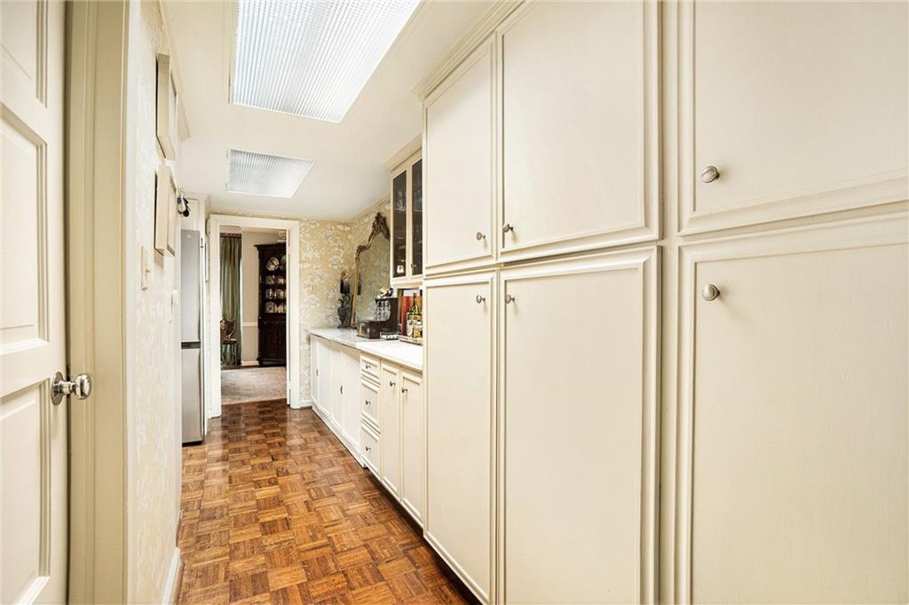 2769 Peachtree Road Northeast, Unit 6 Atlanta, GA 30305 - Photo 11 of 25 a view of a hallway with white cabinets and wooden floor
