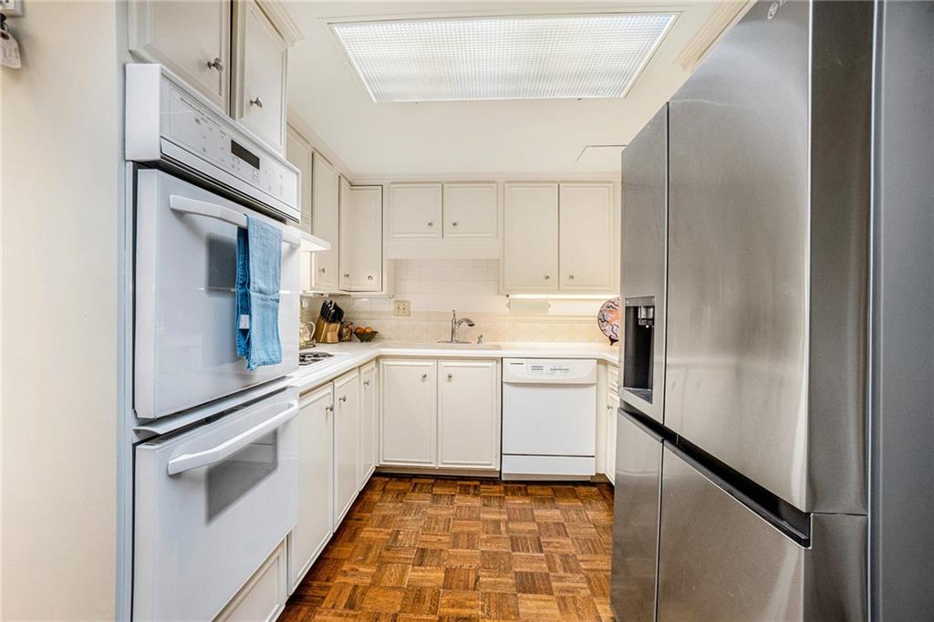 2769 Peachtree Road Northeast, Unit 6 Atlanta, GA 30305 - Photo 9 of 25 a kitchen with white cabinets and white appliances