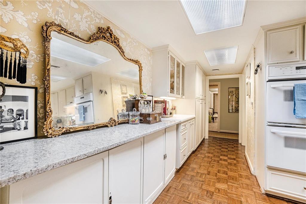 2769 Peachtree Road Northeast, Unit 6 Atlanta, GA 30305 - Photo 10 of 25 a large white kitchen with granite countertop a large counter top and stainless steel appliances