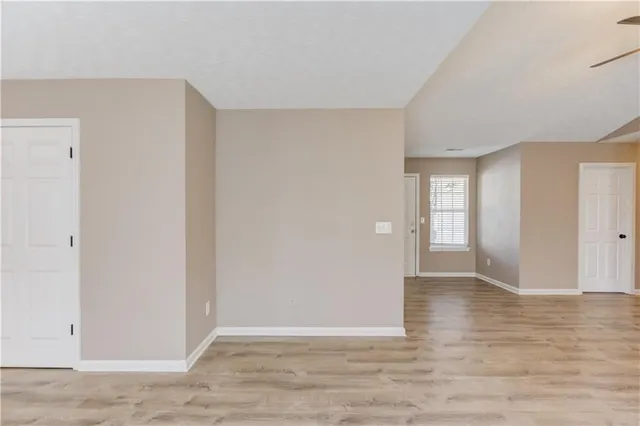 an empty room with windows and cabinet