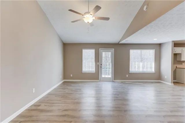 a view of an empty room with window and cabinet