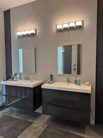 a bathroom with a double vanity sink mirror and