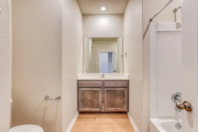 a bathroom with a sink and mirror with toilet