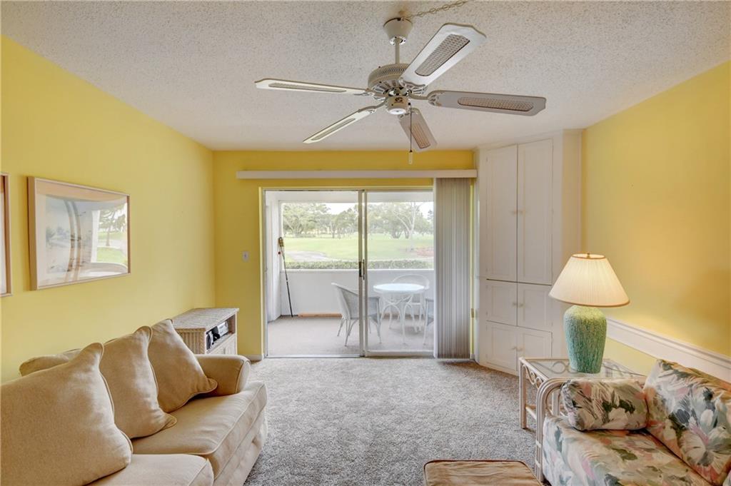 5111 Southeast Miles Grant Road, Unit 104 Stuart, FL 34997 - Photo 11 of 36 a bedroom with a bed and lamp with table
