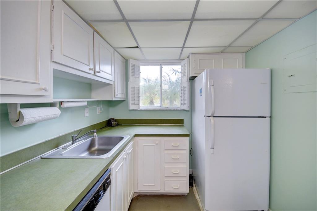 5111 Southeast Miles Grant Road, Unit 104 Stuart, FL 34997 - Photo 14 of 36 a kitchen with a refrigerator and a sink