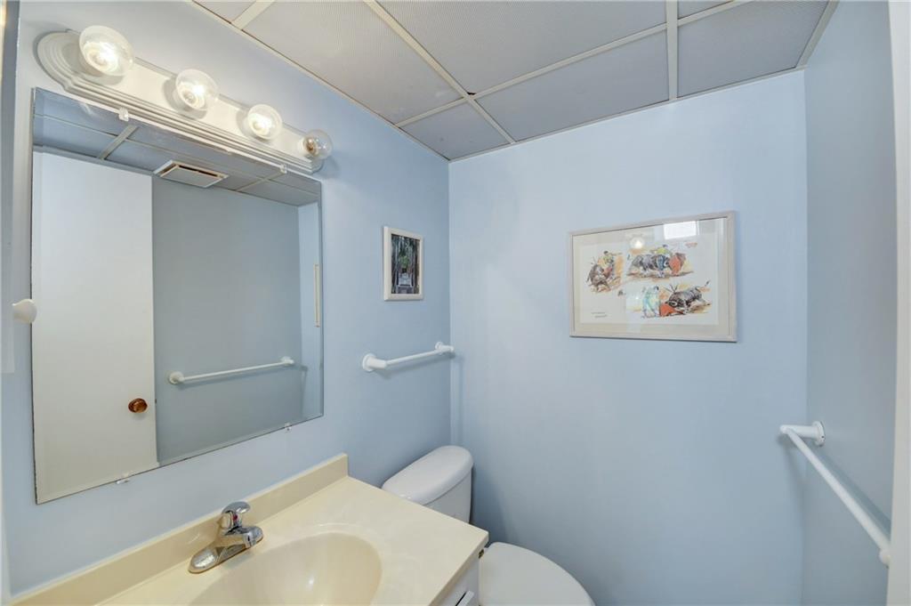 5111 Southeast Miles Grant Road, Unit 104 Stuart, FL 34997 - Photo 15 of 36 a bathroom with a toilet sink and mirror