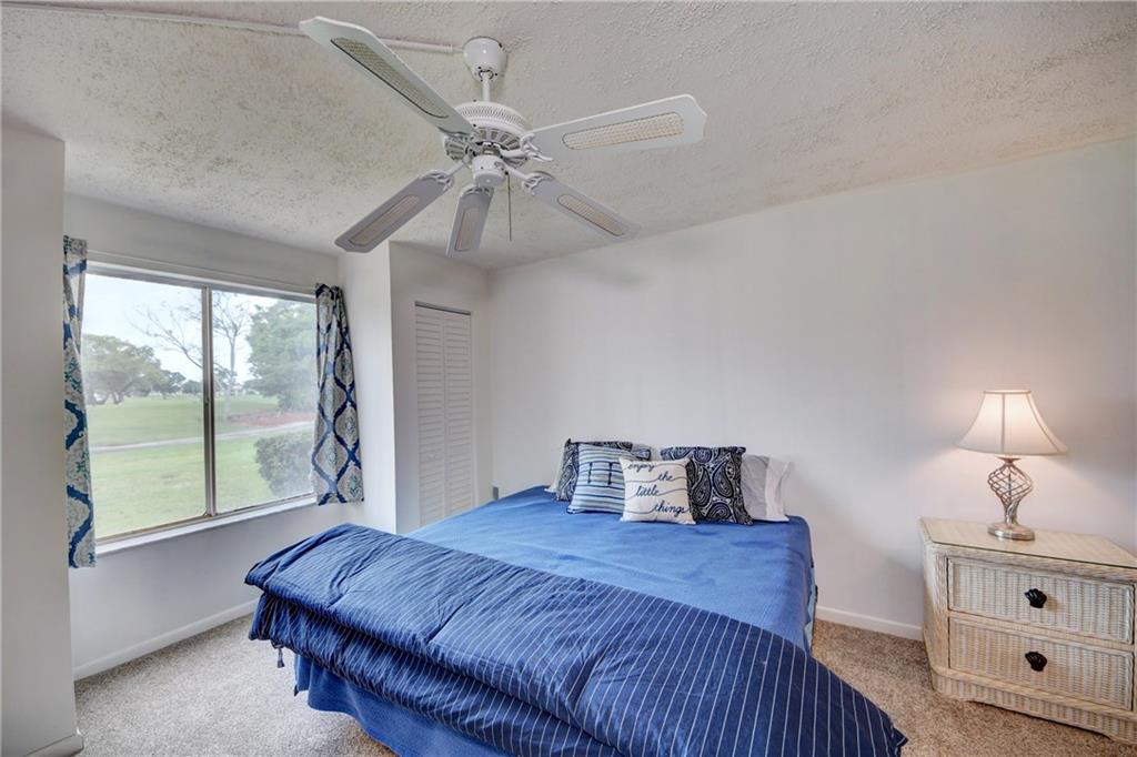 5111 Southeast Miles Grant Road, Unit 104 Stuart, FL 34997 - Photo 18 of 36 a bedroom with a large bed and a window