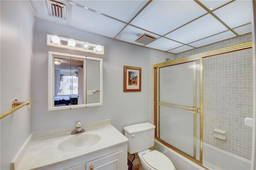 5111 Southeast Miles Grant Road, Unit 104 Stuart, FL 34997 - Photo 20 of 36 a bathroom with a toilet a sink and shower