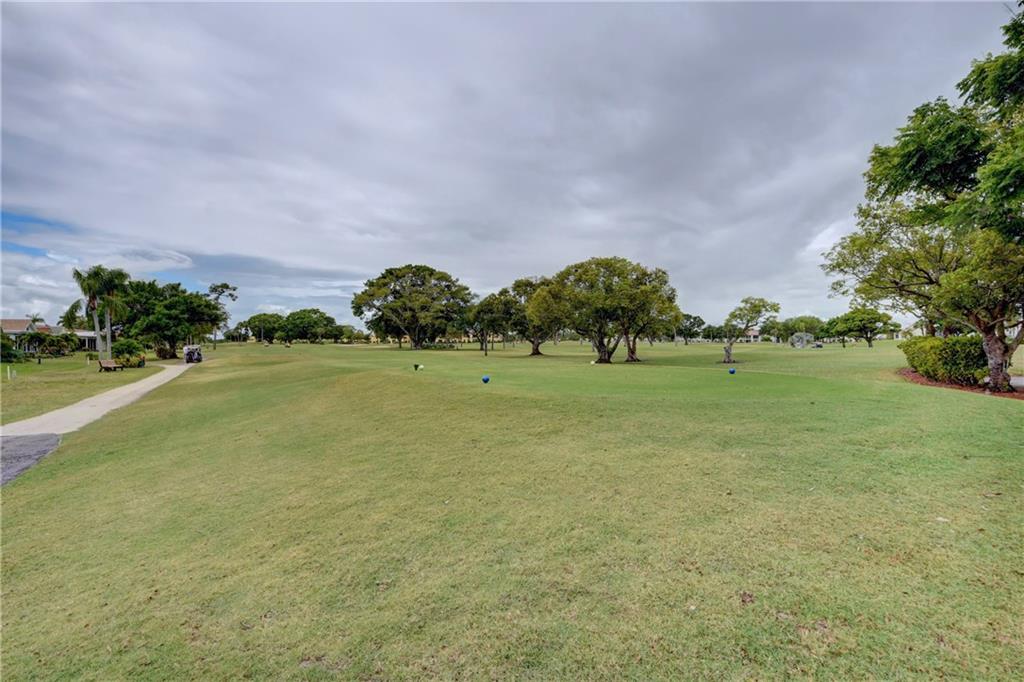 5111 Southeast Miles Grant Road, Unit 104 Stuart, FL 34997 - Photo 27 of 36 a view of a green field with trees in the background