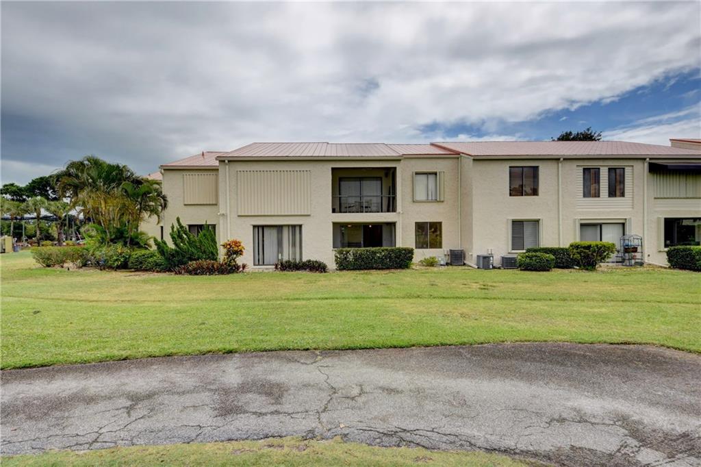 5111 Southeast Miles Grant Road, Unit 104 Stuart, FL 34997 - Photo 28 of 36 a front view of a house with a garden