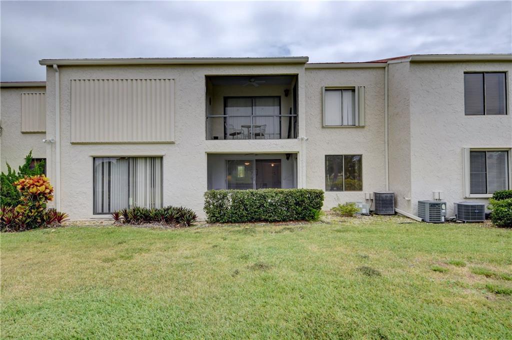 5111 Southeast Miles Grant Road, Unit 104 Stuart, FL 34997 - Photo 29 of 36 a front view of a house with a yard