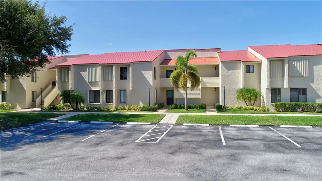 5111 Southeast Miles Grant Road, Unit 104 Stuart, FL 34997 - Photo 30 of 36 a front view of a house with a yard and trees