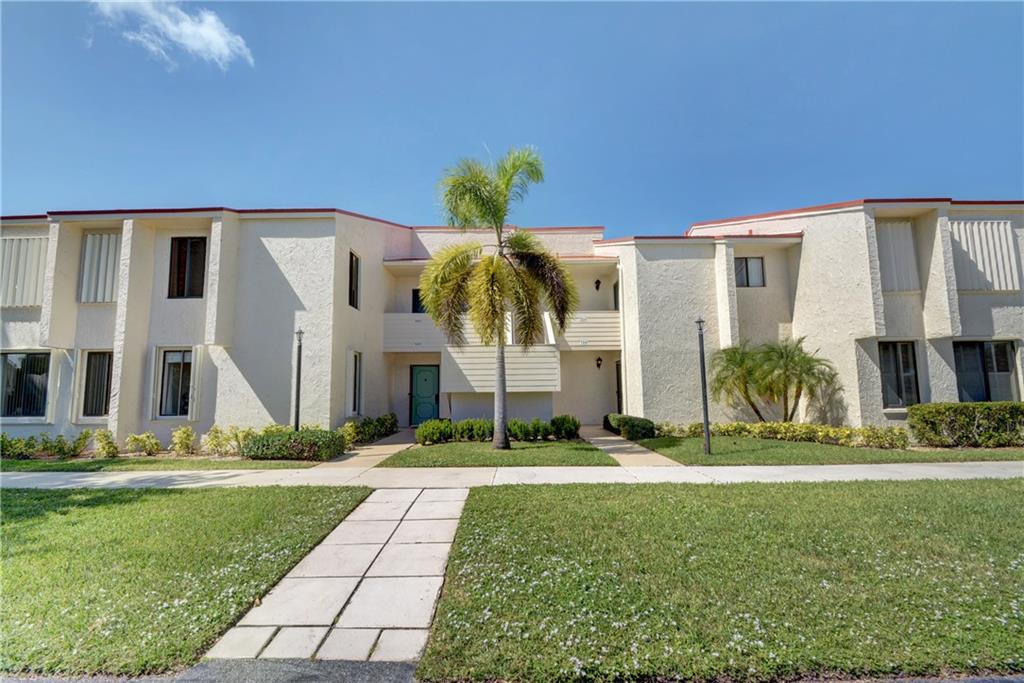 5111 Southeast Miles Grant Road, Unit 104 Stuart, FL 34997 - Photo 3 of 36 a front view of a house with garden