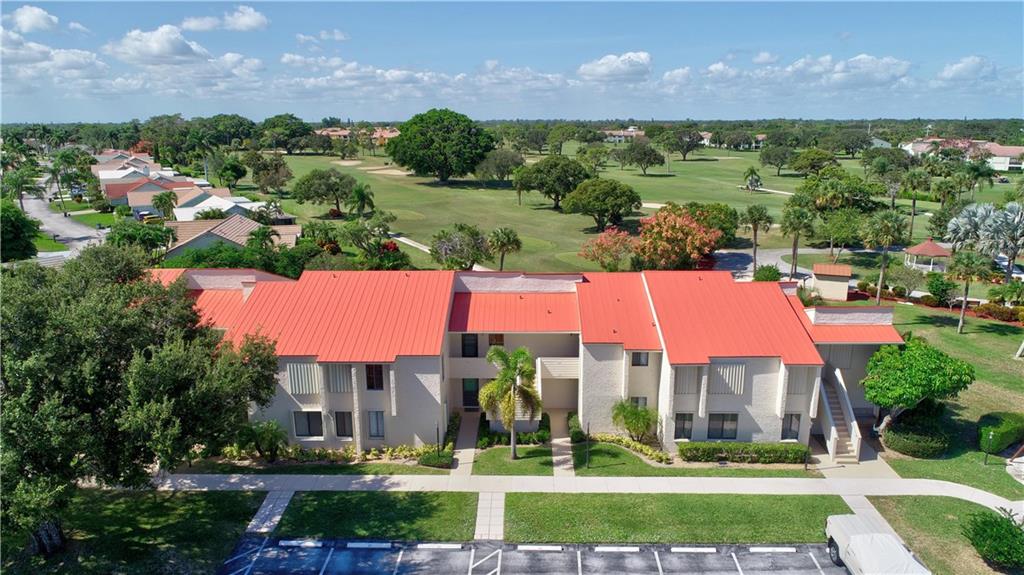 5111 Southeast Miles Grant Road, Unit 104 Stuart, FL 34997 - Photo 32 of 36 a view of a building with a garden and a houses