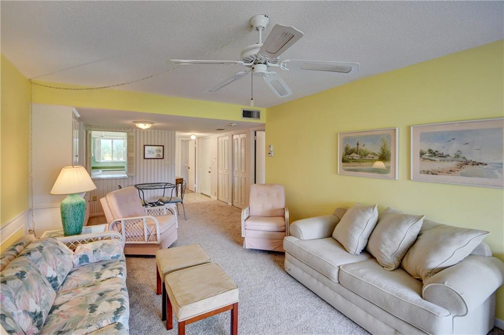 5111 Southeast Miles Grant Road, Unit 104 Stuart, FL 34997 - Photo 9 of 36 a living room with furniture and a chandelier
