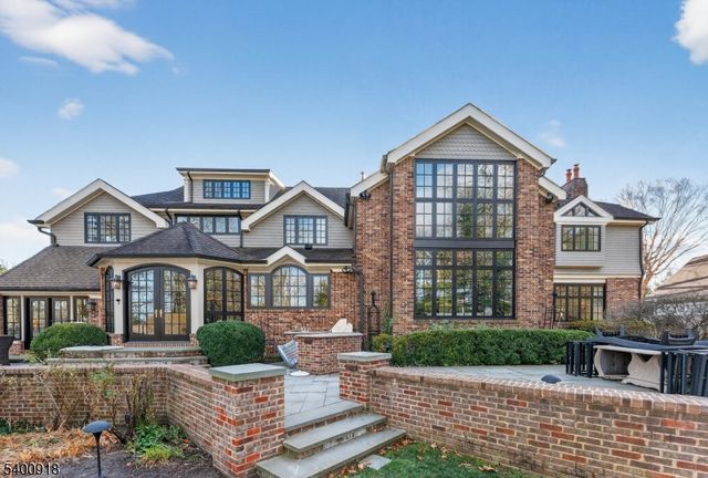 a view of a big house with a big yard and large trees