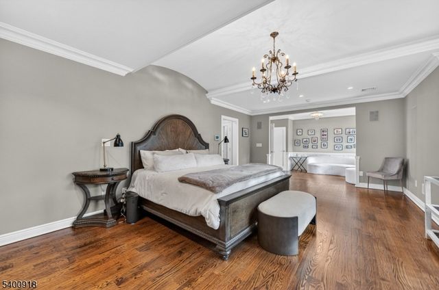 a bedroom with a bed a chair and a large window