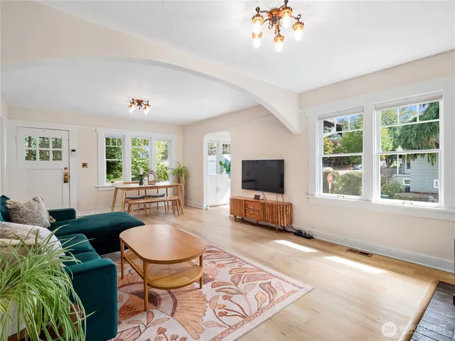 a living room with furniture a flat screen tv and a large window