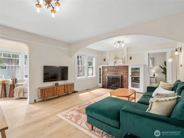 a living room with furniture a flat screen tv and a fireplace