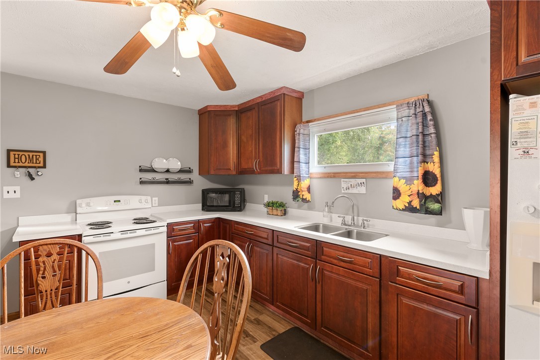 14808 Wheeler Road Lagrange, OH 44050 - Photo 19 of 50 Kitchen with white electric range, light countertops, black microwave, wood finished floors, and fridge