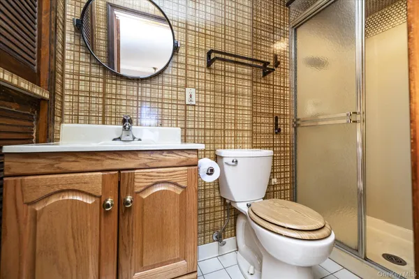 a bathroom with a granite countertop toilet sink and mirror
