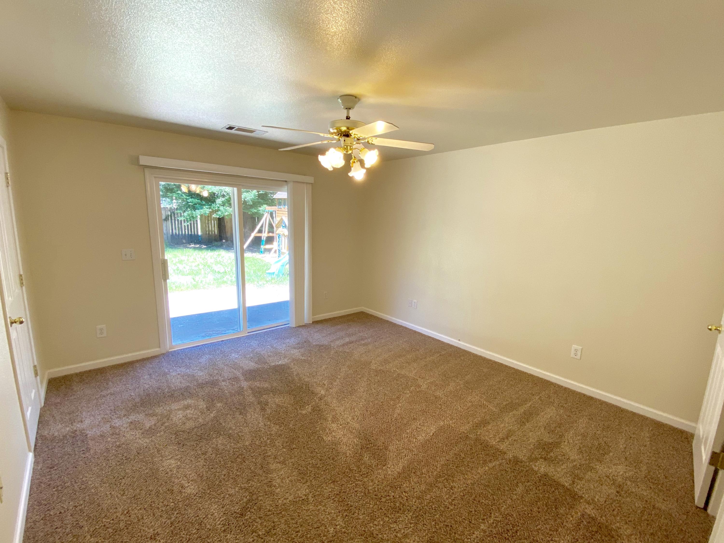 5378 Cedars Road Redding, CA 96001 - Photo 13 of 23 an empty room with a ceiling fan and a window