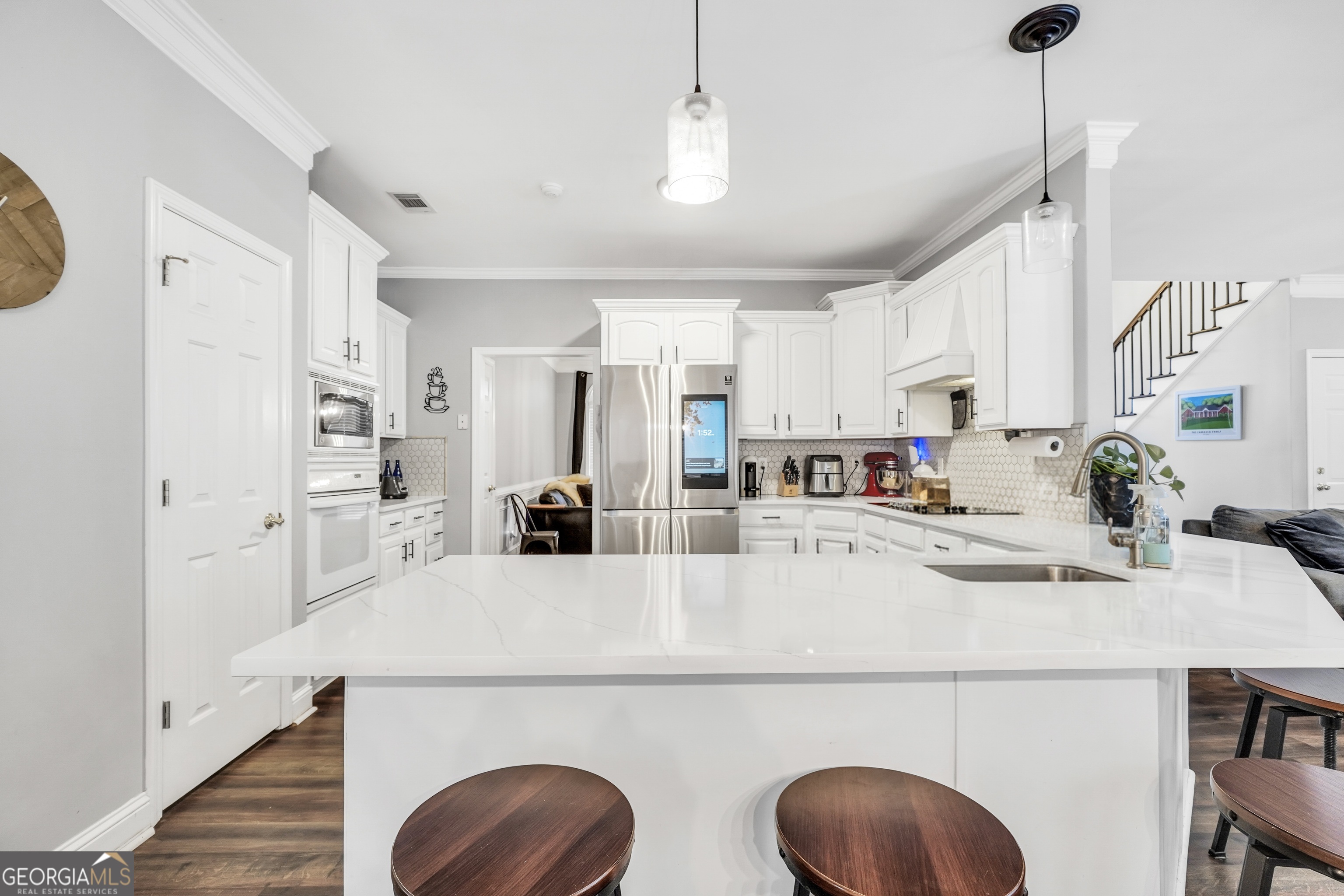 261 Highway 85 Connector Brooks, GA 30205 - Photo 20 of 73 a kitchen with stainless steel appliances a refrigerator a sink a stove and white cabinets with wooden floor