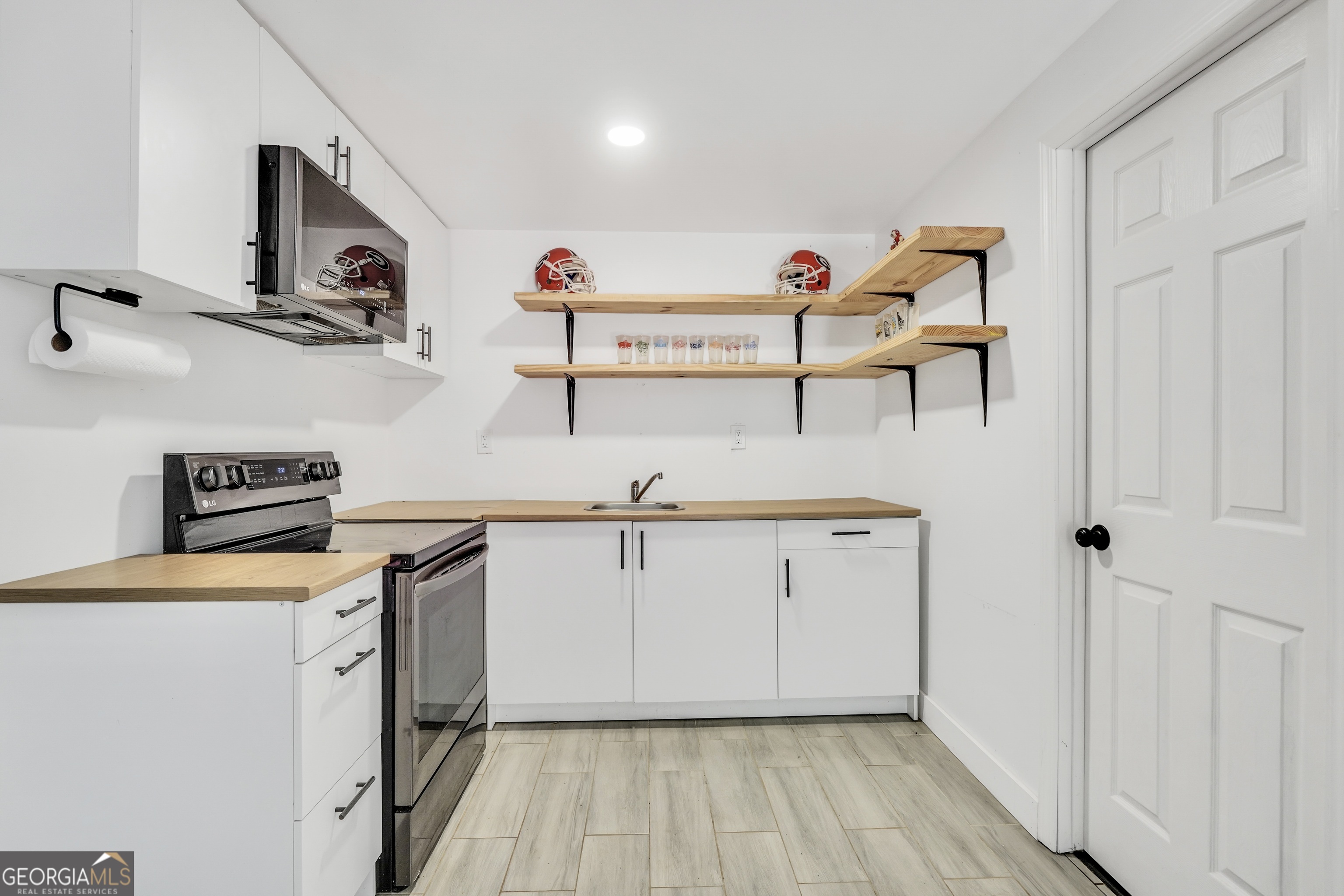261 Highway 85 Connector Brooks, GA 30205 - Photo 46 of 73 a kitchen with stainless steel appliances a white cabinets and a wooden floor