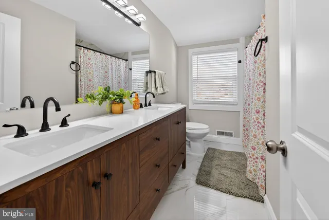 a bathroom with a double vanity sink toilet and shower