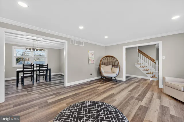 a view of a room with chairs and wooden floor