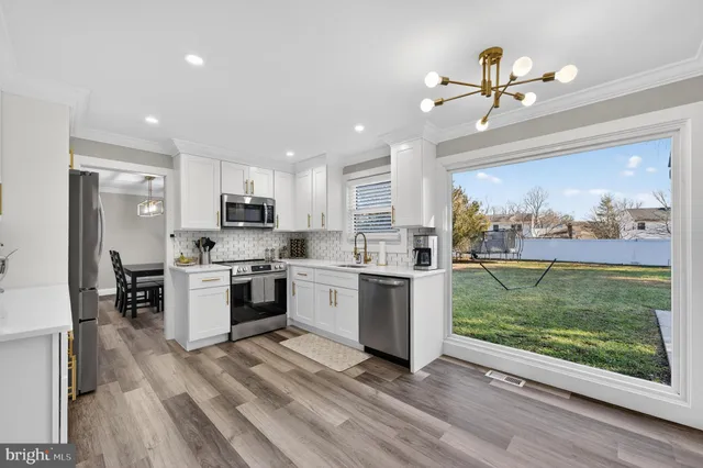 a kitchen with a sink stainless steel appliances and window