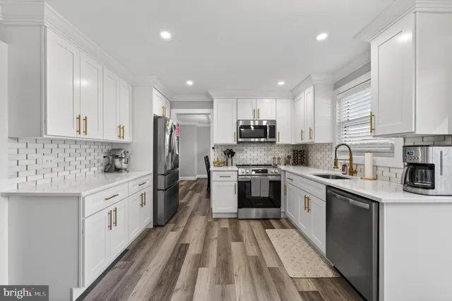a kitchen with white cabinets appliances and sink