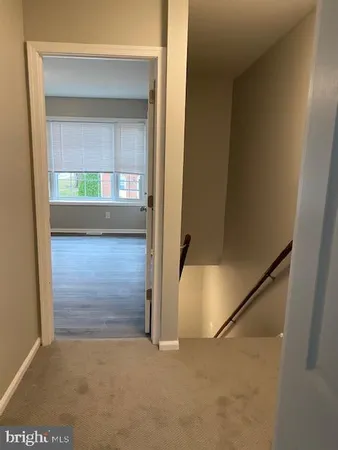 a view of a hallway with wooden floor and a cabinet